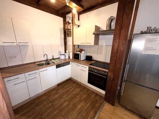 Helle moderne Küche mit Holzverkleidung, Elektrogeräten und ausreichend Stauraum.