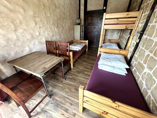 Gemütlicher Schlafraum mit zwei Etagenbetten und einem Tisch aus Holz.